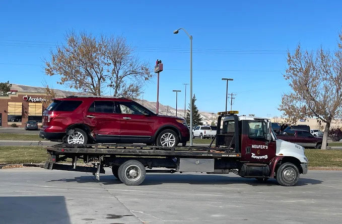 General-Towing Nuefer's Towing & Recovery flat bed truck Hauling a red SUV