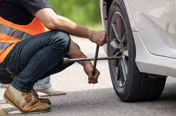 Roadside-service-tire-change Neufer's towing at a roadside service changing a tire.